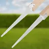 Two metal post anchors attached to wooden posts, set against a blurred background of green grass and a blue sky. Podgląd zdjęcia produktu