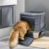 A fluffy cat is using an automatic litter box in a bathroom setting. Náhľad obrázku produktu