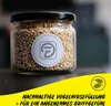A jar filled with small seeds, possibly birdseed, with a logo on the jar and text overlay at the bottom. Produktbild-Vorschau