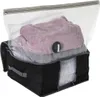 A vacuum storage bag filled with blankets and sweaters, with a valve for air removal. Produktbild-Vorschau