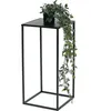 A black metal plant stand with a potted plant on top. Produktbild-Vorschau
