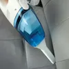 A hand is using a white and blue handheld vacuum cleaner to clean a car seat. Náhled obrázku produktu