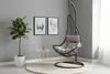 A hanging chair is set up in a room with a plant and artwork on the wall. Produktbild-Vorschau