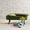 A green storage bench with a pillow and books in front of a terrazzo-patterned wall. Produktbild-Vorschau