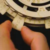 A close-up of a hand adjusting a wooden perpetual calendar. Anteprima dell’immagine prodotto