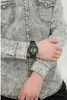 A person wearing a gray denim shirt and a black G-Shock watch. Náhľad obrázku produktu
