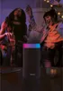 Two women dancing at a party, with a speaker in the foreground. Voir les images du produit