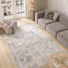 A modern living room with a large rug, sofa, and ottoman. Anteprima dell’immagine prodotto