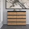 A modern dresser with eight drawers is shown in a room with patterned wallpaper and a large abstract painting above it. Produktbild-Vorschau