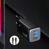 A black and gray USB charger with two USB-C ports and one USB-A port, plugged into an unseen power source, with a cable shown in a circular inset. Podgląd zdjęcia produktu