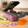 A kitchen counter with a vegetable chopper and various chopped vegetables. Náhled obrázku produktu