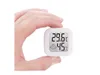 A hand holds a small white digital thermometer and hygrometer. Podgląd zdjęcia produktu