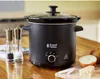 A black Russell Hobbs slow cooker is placed on a wooden table, surrounded by salt and pepper grinders, onions, and cheese. Anteprima dell’immagine prodotto