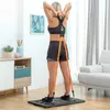 A woman is performing an exercise using a portable full-body training system in a room. Podgląd zdjęcia produktu