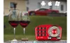 A red retro radio is placed on a surface with two glasses of red wine and a cork in front of a blurred background of a house and a red car. Produktbild-Vorschau