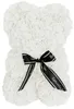 A white rose bear with a black ribbon tied around its neck.