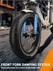 Close-up of the front fork and wheel of an electric bicycle, with text overlay describing the damping system. Produktbild-Vorschau