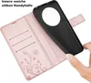 A hand is holding a black phone case over an open rose gold wallet case with card slots and a floral butterfly design. Produktbild-Vorschau