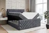 A dark gray velvet boxspring bed with a lifted mattress and storage compartment is shown in a bedroom setting. Produktbild-Vorschau