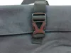 A close-up of a black buckle on a dark gray fabric bag. Produktbild-Vorschau