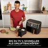 A man is preparing food in a kitchen next to a Ninja Foodi MAX DualZone air fryer. Produktbild-Vorschau