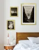 A bedroom scene with framed pictures on the wall above a bed. Produktbild-Vorschau