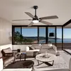 A living room with a ceiling fan, sofas, a coffee table, and a large window overlooking a beach and ocean. Produktbild-Vorschau