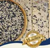 A wooden bowl filled with birdseed, with some seeds scattered on a wooden surface. A golden badge with text is overlaid on the bottom right. Produktbild-Vorschau