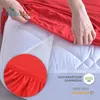 A person is putting a red fitted sheet onto a mattress. There is a close-up inset showing the elastic edge of the sheet. Produktbild-Vorschau