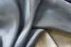 A close-up view of draped gray sheer fabric, possibly curtains, with a tan fabric visible underneath. Produktbild-Vorschau