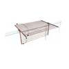 A drying rack is mounted on a white railing, with arrows indicating movement. Voir les images du produit