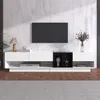 A modern living room setup featuring a white lowboard media console with a black cube insert, a large black television mounted on a light gray marble-patterned wall, and decorative items. Produktbild-Vorschau