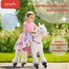 A young girl riding a white toy horse in an outdoor setting. Anteprima dell’immagine prodotto