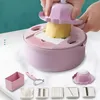 A pink multi-functional vegetable cutter set is displayed with various attachments and a potato being cut. Náhľad obrázku produktu