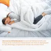 A person sleeping under a white duvet. Voir les images du produit
