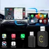 A car's dashboard displaying a smartphone interface, with two USB adapters in the foreground. Produktbild-Vorschau