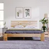 A wooden bed frame with a headboard and mattress in a bedroom setting. Náhled obrázku produktu