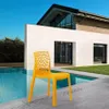 A yellow chair is placed next to a swimming pool in front of a modern house. Produktbild-Vorschau