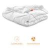 A folded white comforter is shown against a white background, with two circular icons and text below. Voir les images du produit