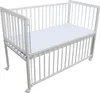 A white baby crib with a mattress on a white background. Produktbild-Vorschau