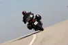 A person riding a motorcycle on a road. Produktbild-Vorschau