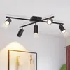 A black ceiling spotlight fixture with five adjustable heads is mounted on a white ceiling. Náhled obrázku produktu