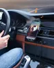A person's hand is on the steering wheel of a car, with a phone mounted on the dashboard playing music. Náhľad obrázku produktu