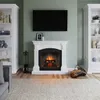 A living room scene with a fireplace, bookshelves, and a rug. Produktbild-Vorschau