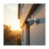 A security camera mounted on the side of a house during sunset. Podgląd zdjęcia produktu