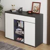 A modern shoe cabinet with two doors and a drawer, featuring open shelving with LED lighting, placed in a home entryway. Anteprima dell’immagine prodotto