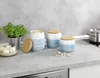 A kitchen counter with storage jars, onions, and a pot on a stove. Produktbild-Vorschau