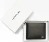 A black Lacoste wallet is presented in its white packaging box, which is slightly ajar. Produktbild-Vorschau