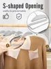 A close-up demonstration of a gray clothing hanger with an S-shaped opening being used to hang a tan sweater. Produktbild-Vorschau
