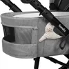 A close-up view of a gray baby stroller basket with a small stuffed toy attached. Anteprima dell’immagine prodotto
